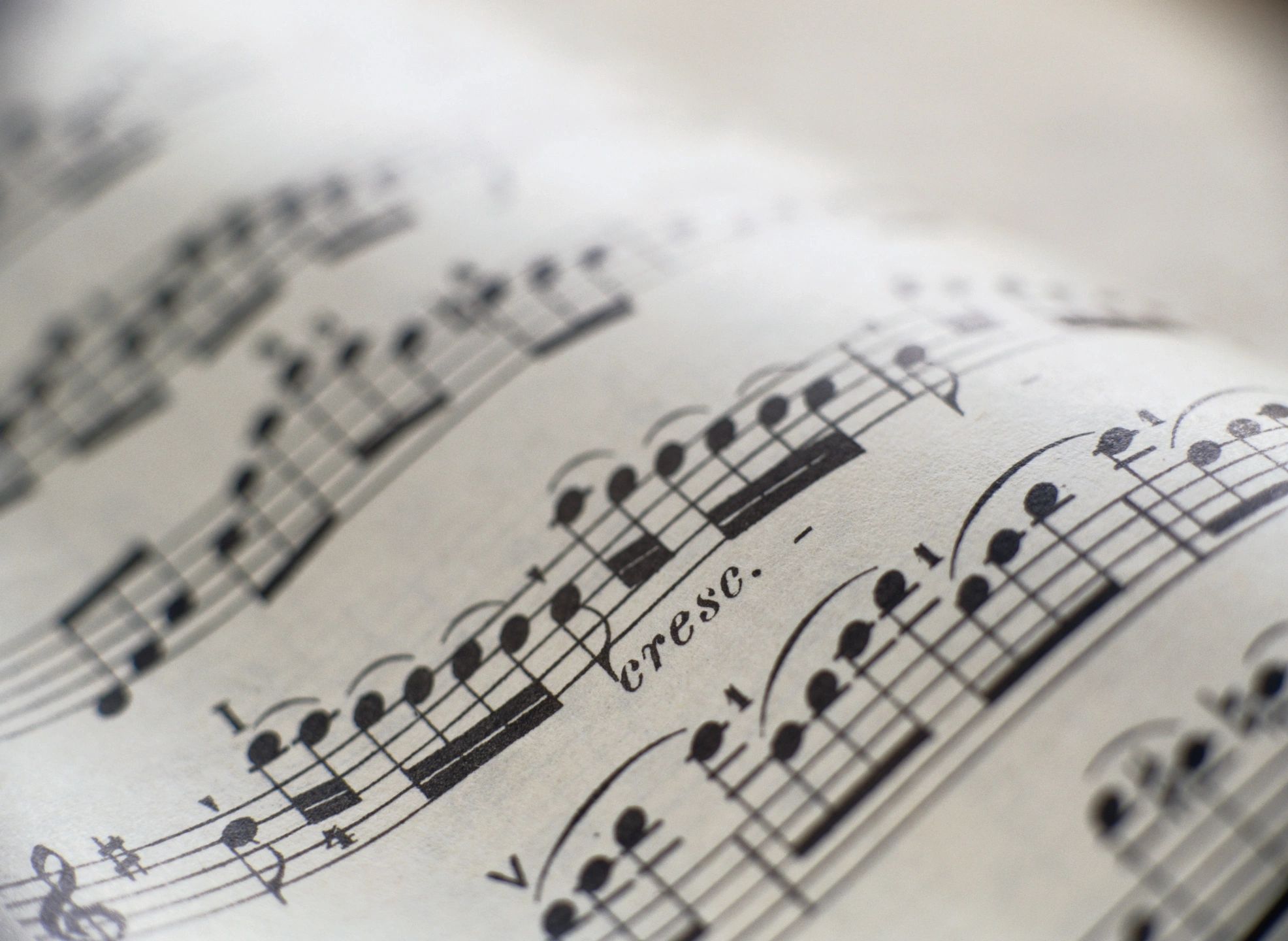 Sheet music in an attractive wave curve of the page with sun in background.
